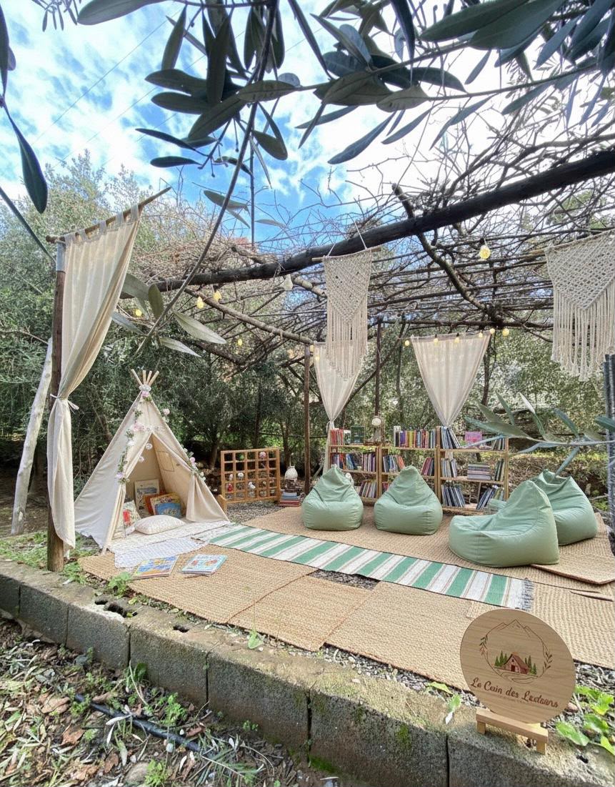 Coin lecture privé avec tipi, poufs et bibliothèque sous les oliviers du domaine Tayri Aura